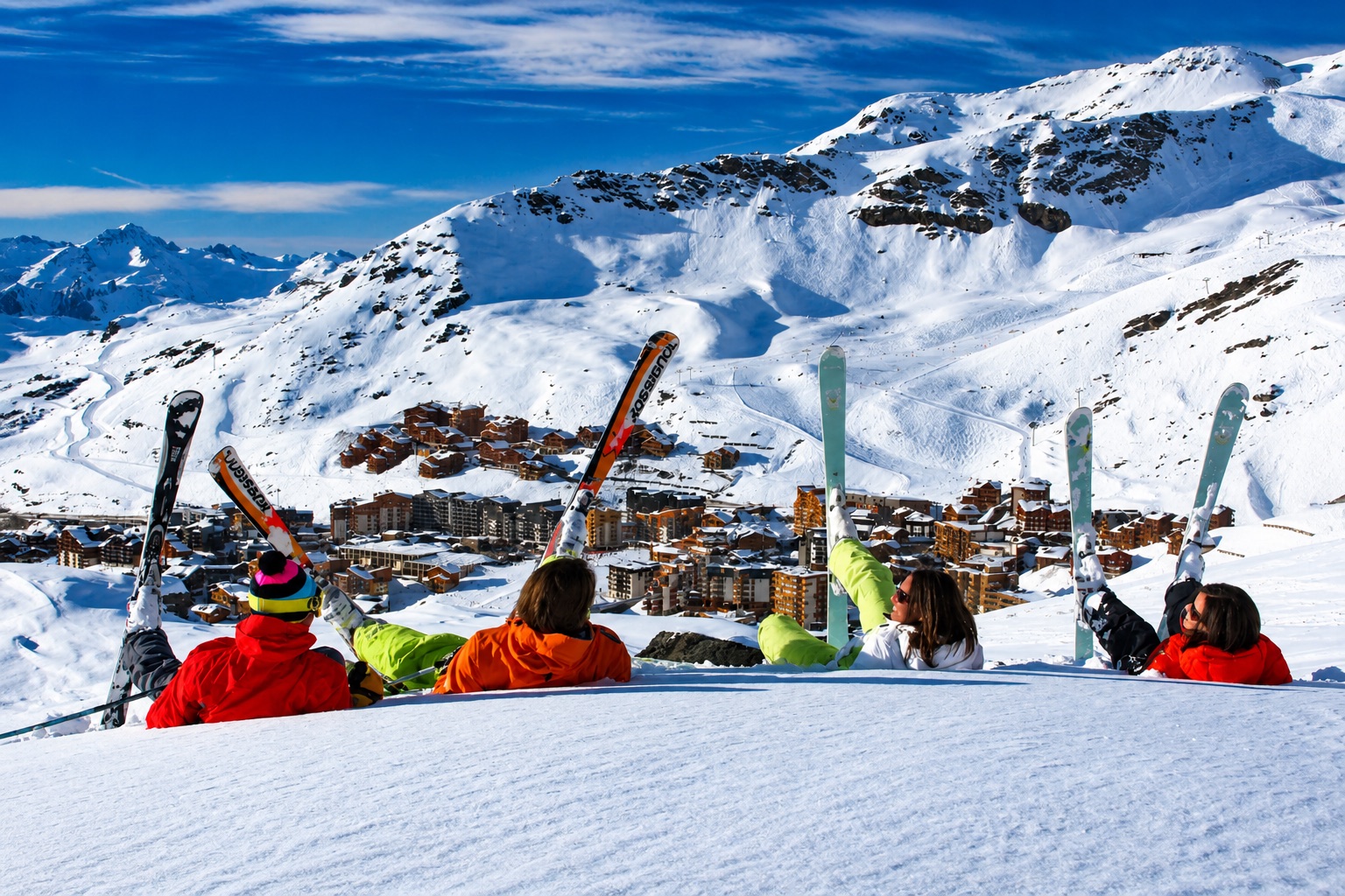 Skiers overlooking a snowy mountain resort